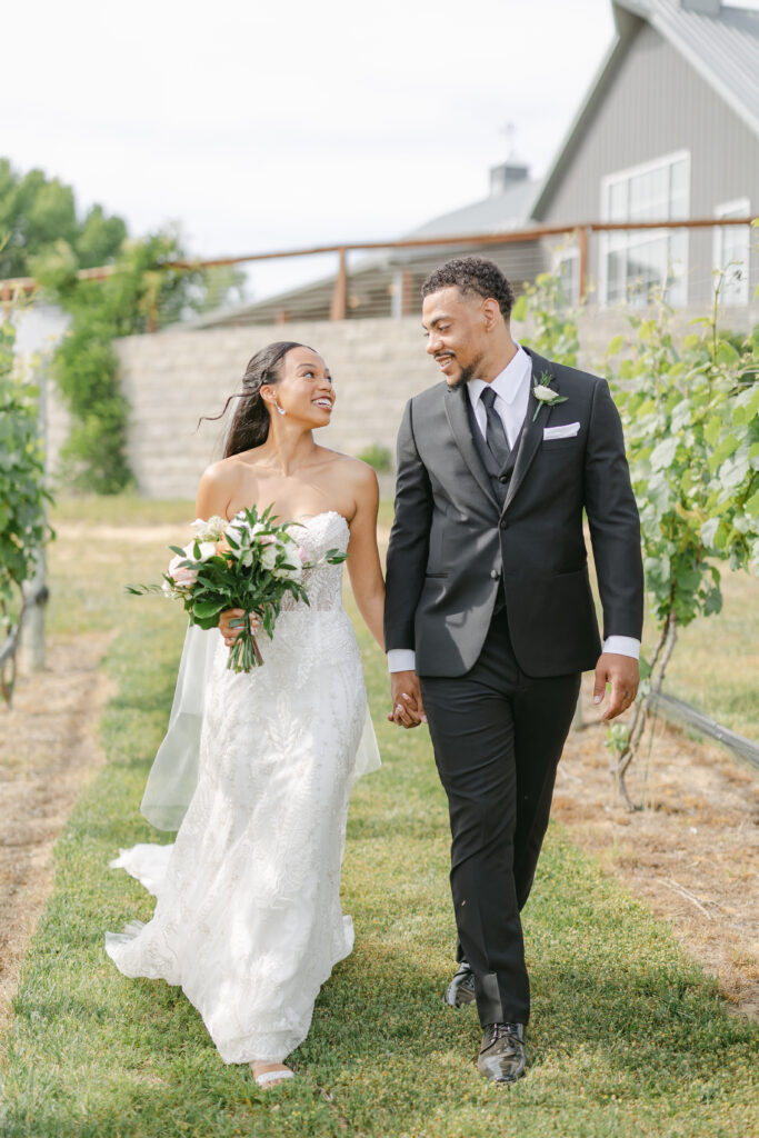 Bride and groom walking together at Two Lions Vineyard on their wedding day.